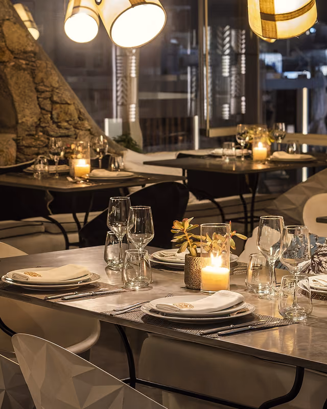 Candlelit tables set for dinner on the Krama terrace at night, Mykonos Town
